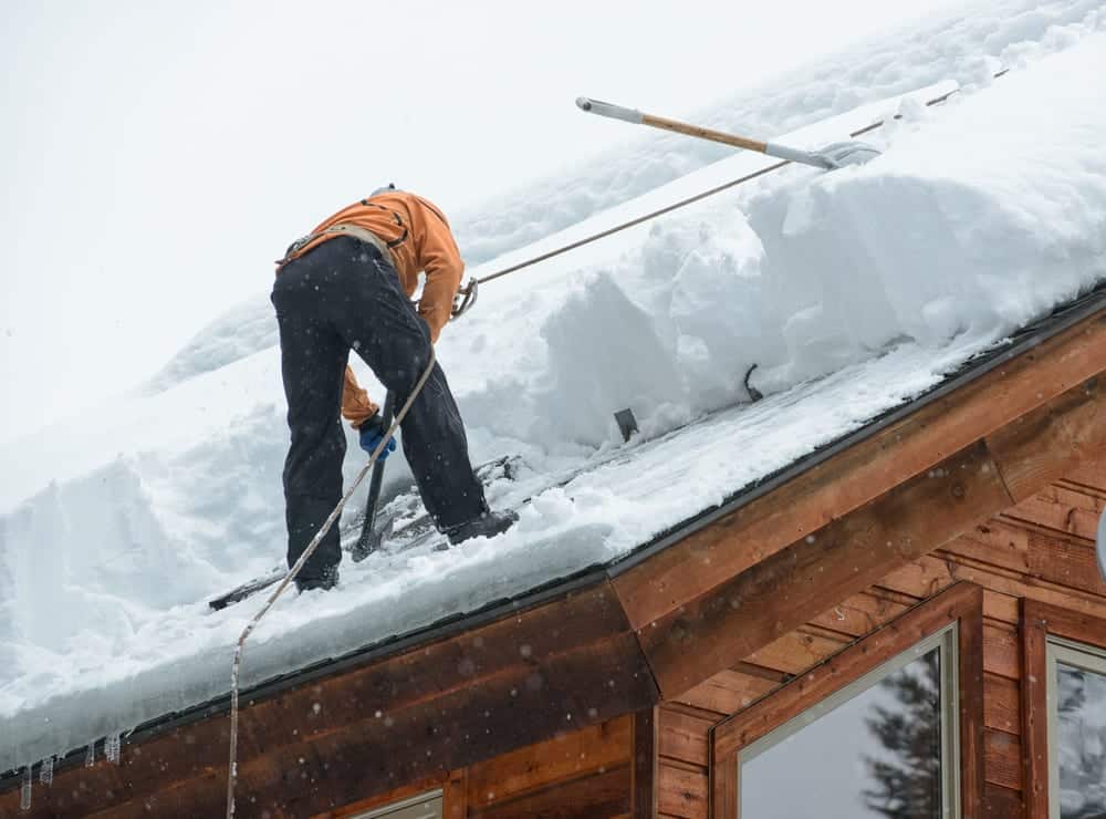 Mean on roof clearing ice dam